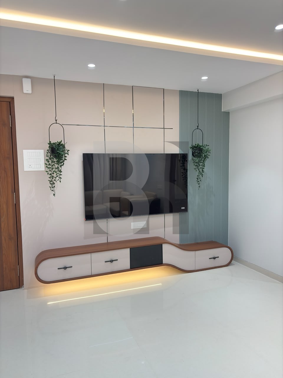 Living room TV accent wall with curved floating media unit and sage green fluted panel by Brand Meter