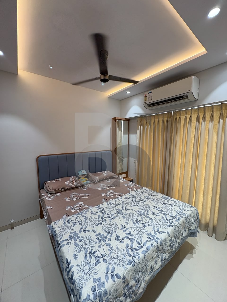 Modern master bedroom with blue tufted headboard and warm LED cove lighting by Brand Meter, Navi Mumbai