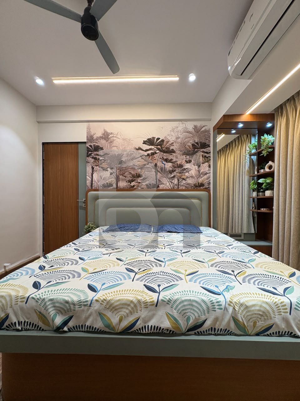 Luxury bedroom with tropical wallpaper accent wall and king-size padded headboard by Brand Meter
