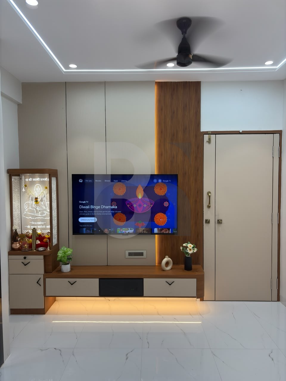 Living room media center with integrated home mandir and backlit TV accent paneling by Brand Meter