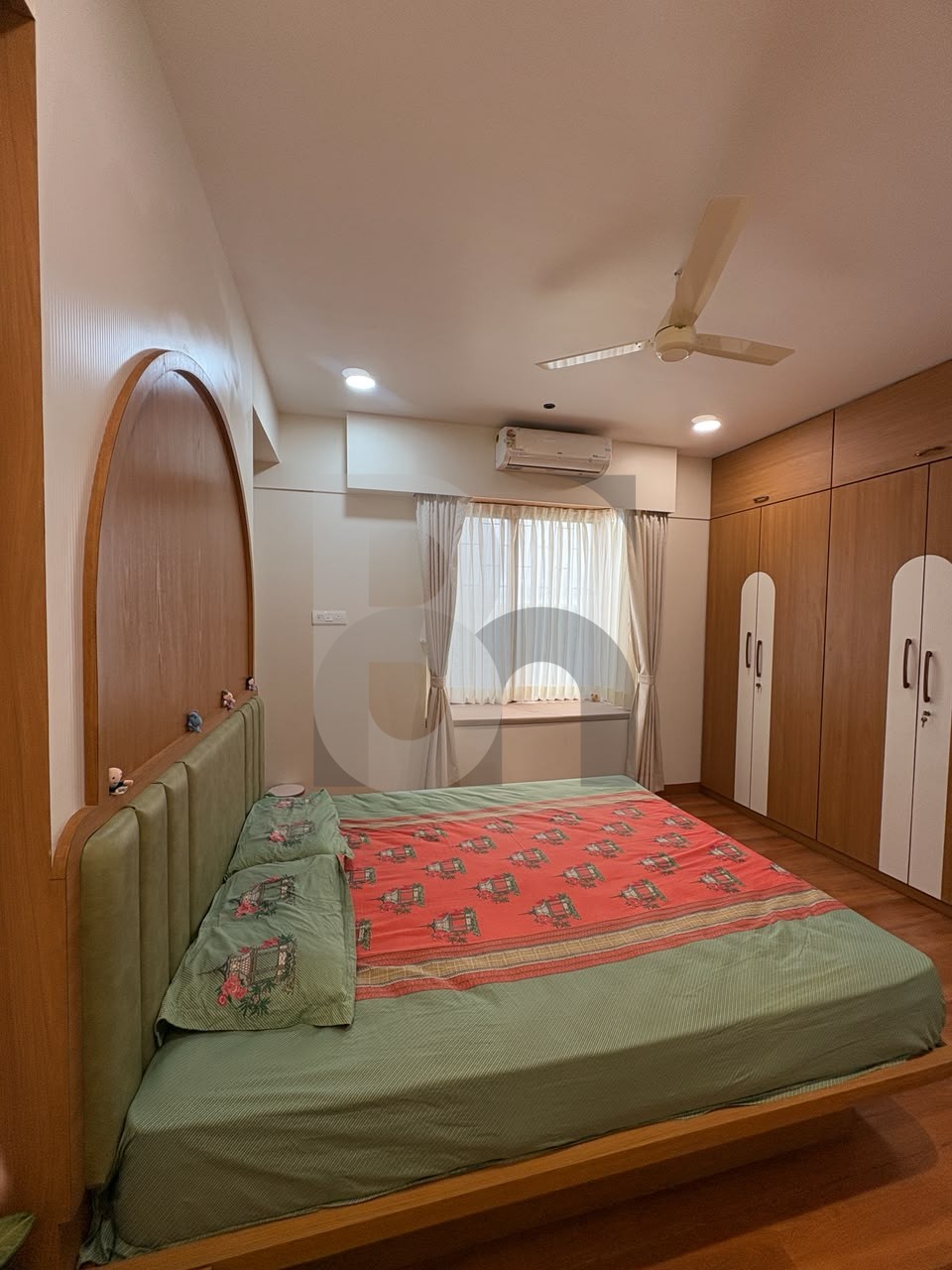 Bedroom with arched wood panel headboard and full-height wardrobe with white accents by Brand Meter
