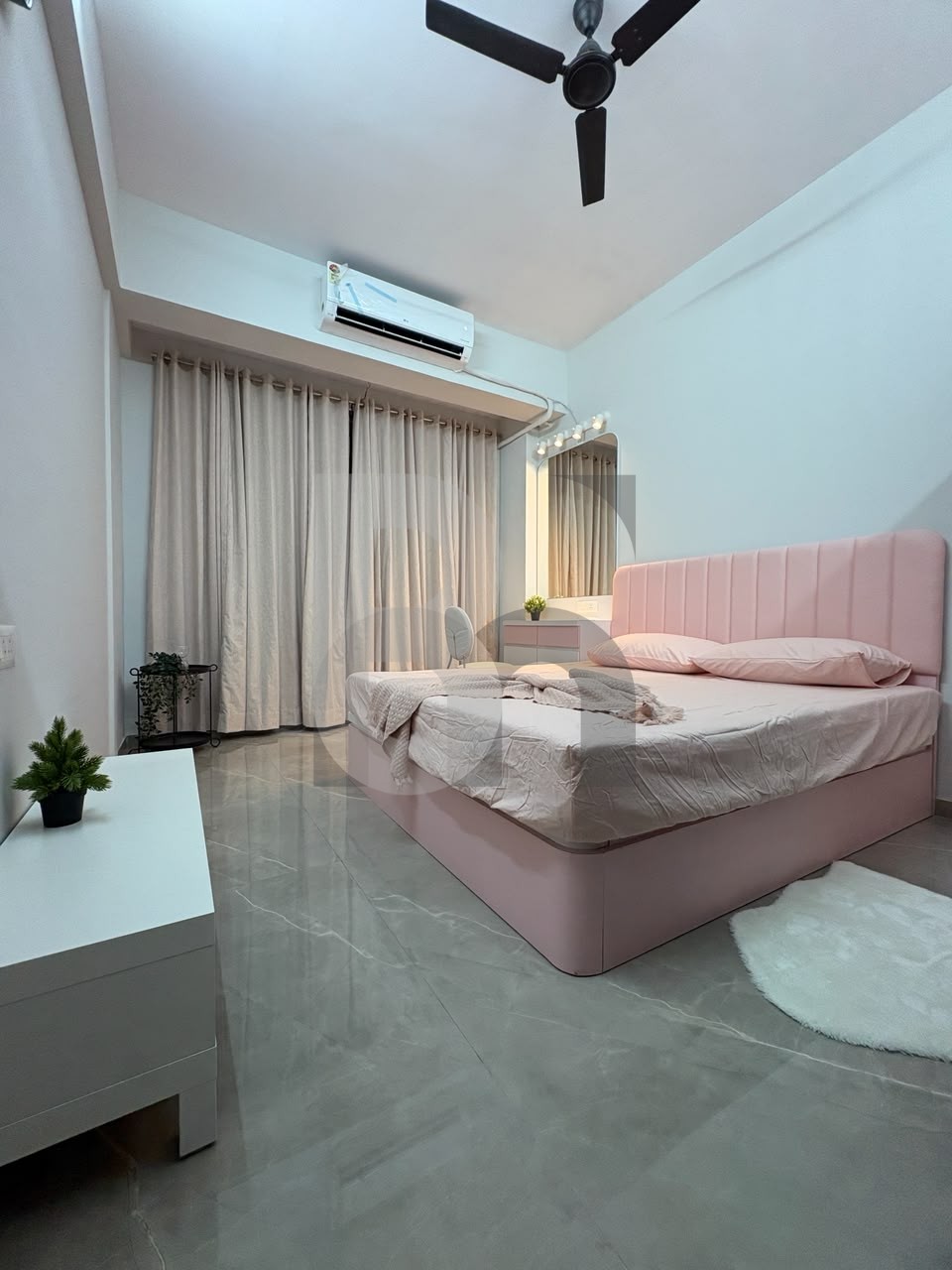 Modern bedroom with pastel pink channel-tufted velvet bed and vanity mirror by Brand Meter