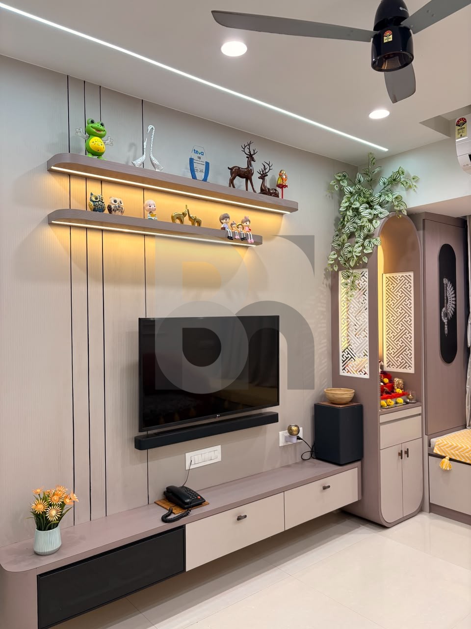 Living room entertainment wall with LED backlit display shelves and integrated pooja unit by Brand Meter