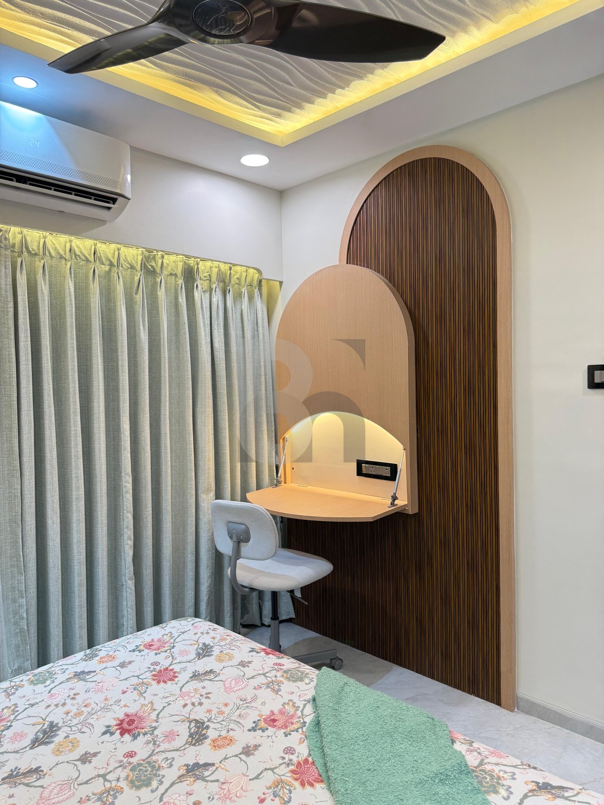 Bedroom study nook with arched fluted wood panel, floating table, and modern task chair by Brand Meter