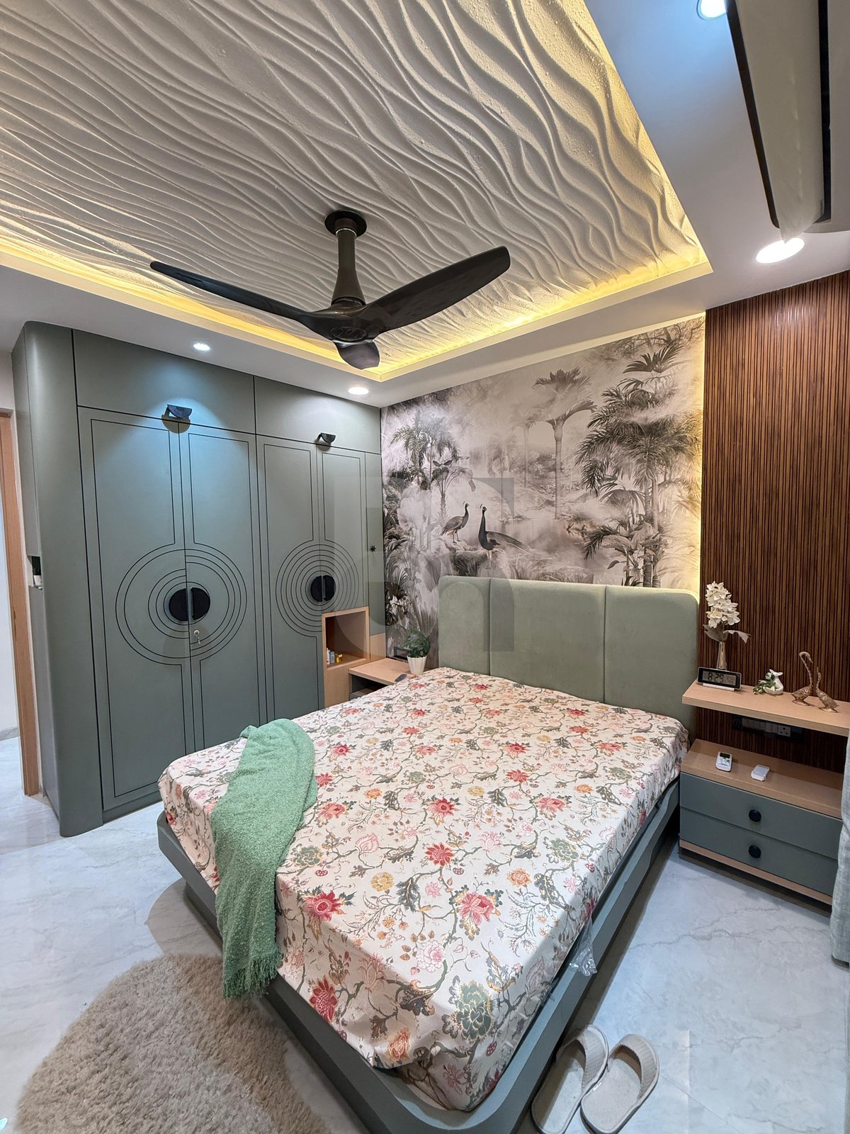 Sage green sliding wardrobe with circular geometric detailing and matching bedroom finish by Brand Meter, Vashi