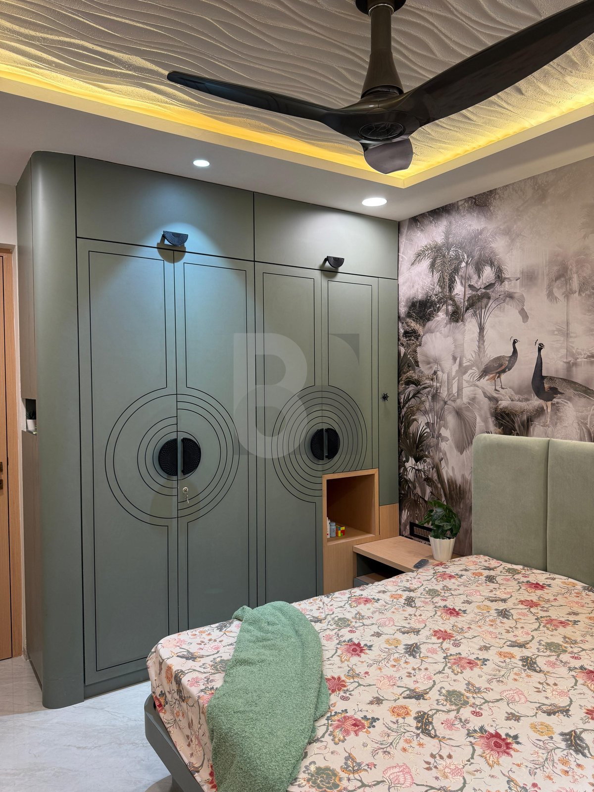 Bedroom view showing sage green wardrobe with circular ring handles and fluted side niches by Brand Meter