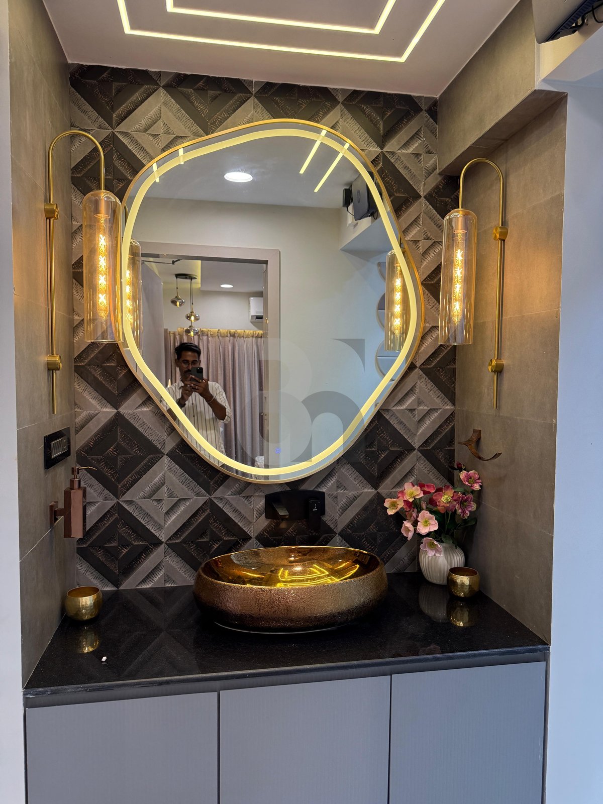 Luxury powder room vanity with golden artisan basin, organic LED backlit mirror, and designer tile wall by Brand Meter